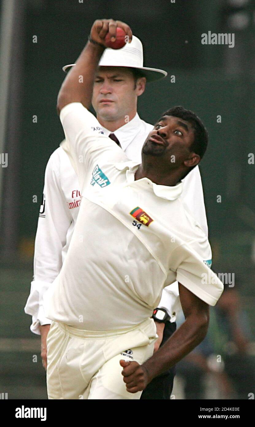 Sri Lankan bowler Muttiah Muralitharan (R) pitches a delivery as Australian umpire Simon Taufel looks on during their first day of first test cricket match against West Indies in Colombo, Sri Lanka, July 13, 2005. REUTERS/Anuruddha Lokuhapuarachchi  AL/PN Stock Photo