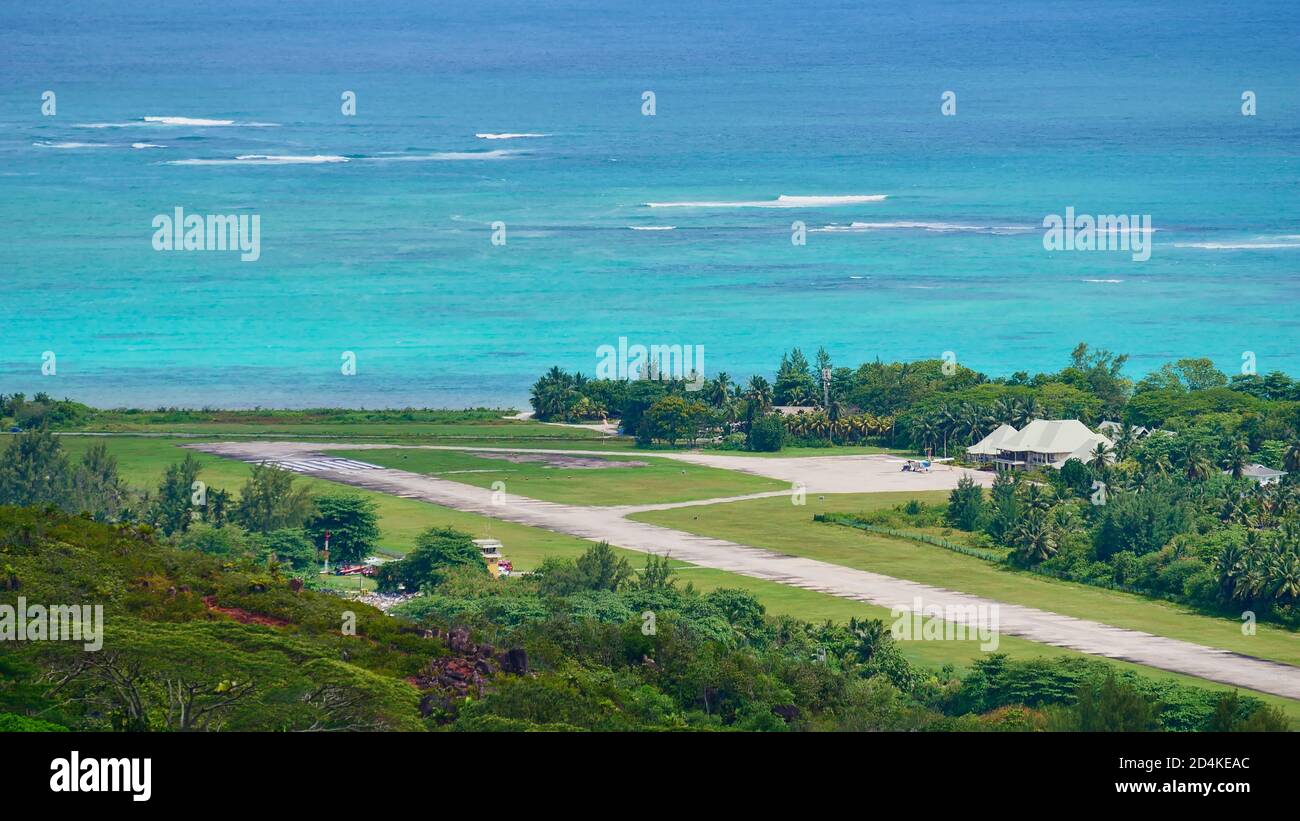 Aerial view of airfield located near the coast in the north of Praslin island, Seychelles with a small plane parking in front of the terminal building. Stock Photo