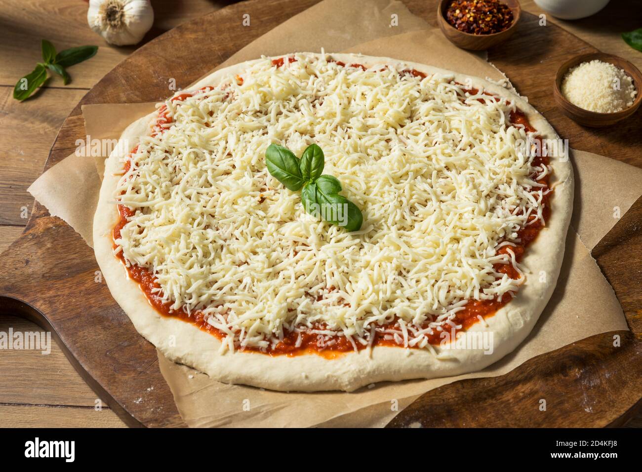 Preparing Homemade Uncooked Cheese PIzza with Sauce and Dough Stock