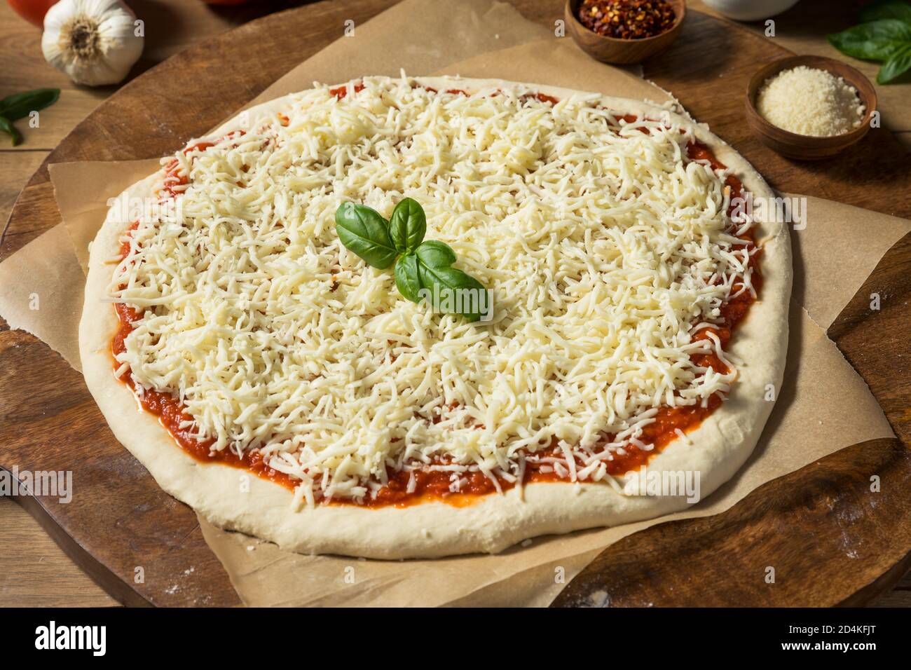 Preparing Homemade Uncooked Cheese PIzza with Sauce and Dough Stock