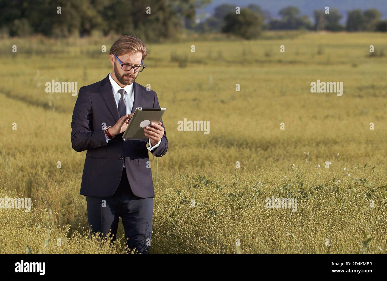 Man holding tablet standing field Stock Photo