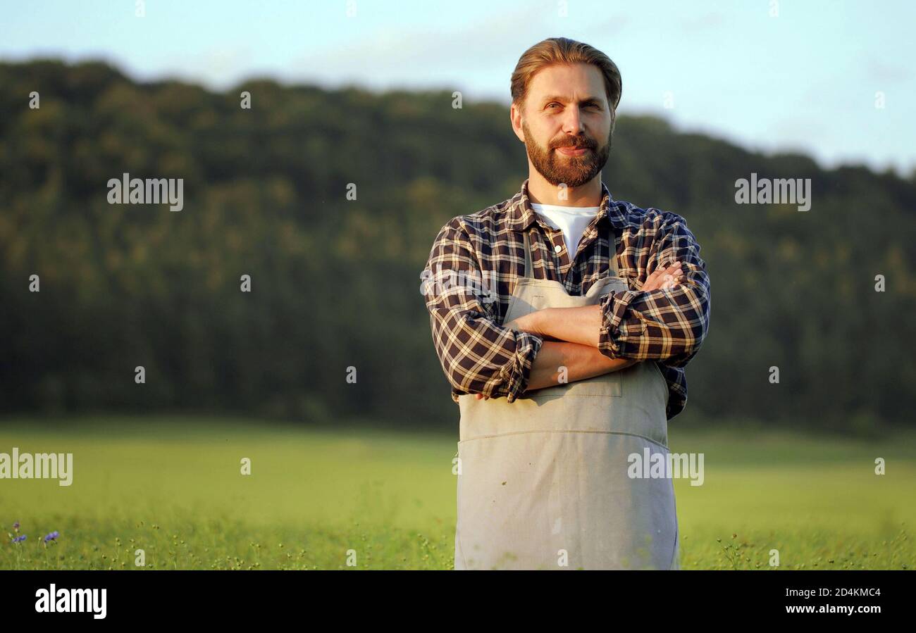 Agrarian standing on green field Stock Photo