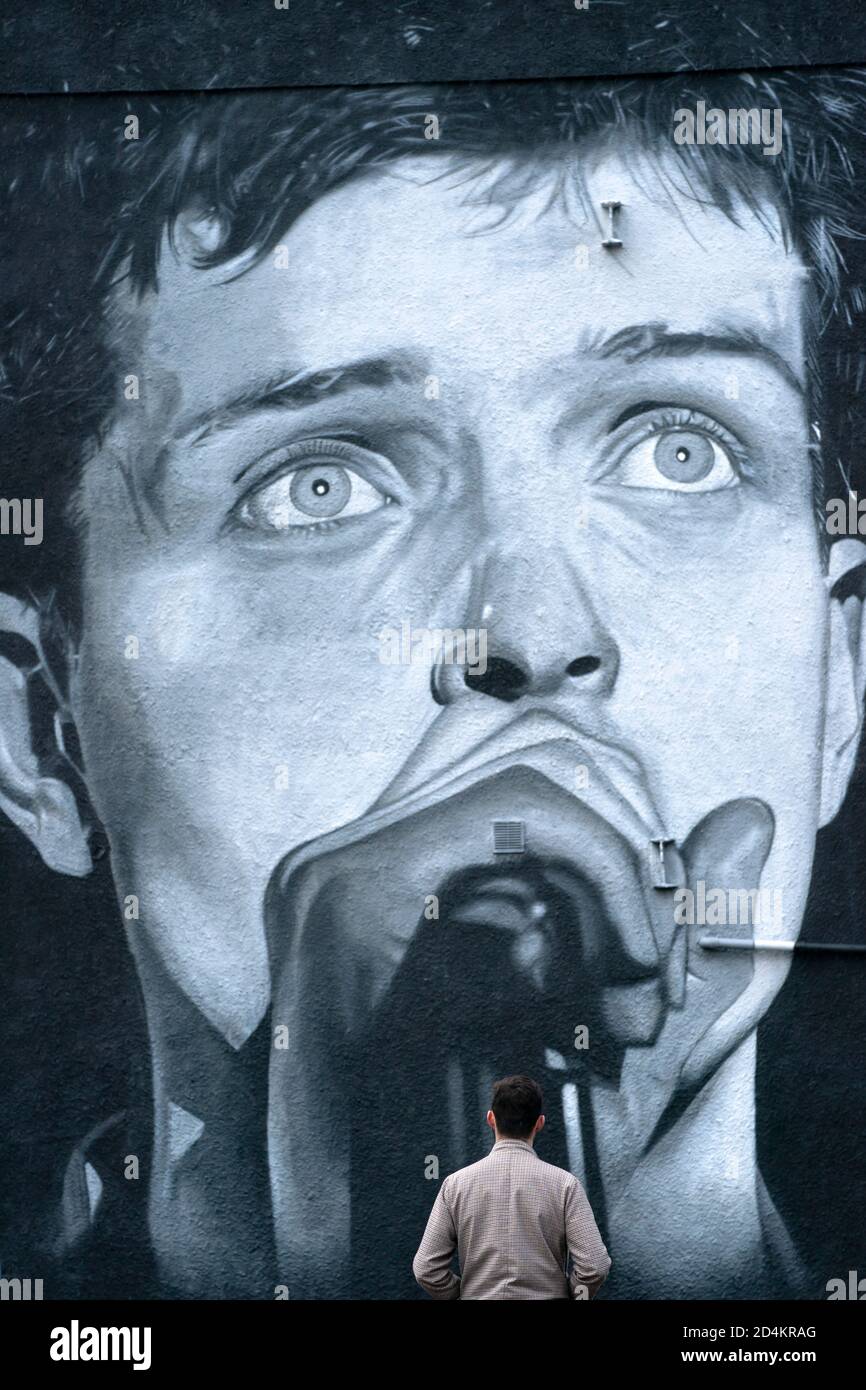 Manchester, UK. 9th October, 2020. A recently completed mural of former Joy  Division singer Ian Curtis who died by suicide in 1980 and painted by  street artist AkseP19 is seen in central