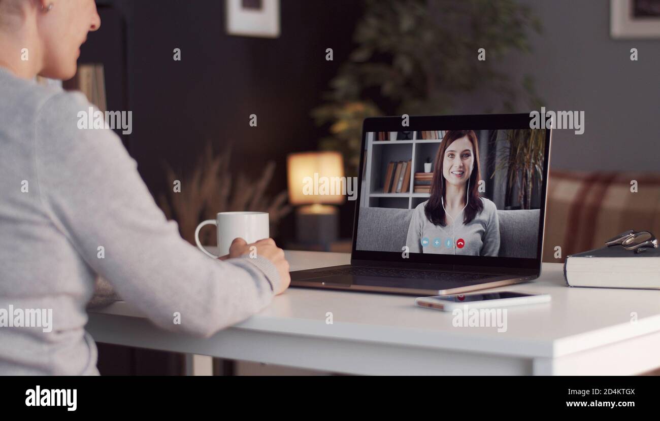 Woman using laptop calling friend Stock Photo