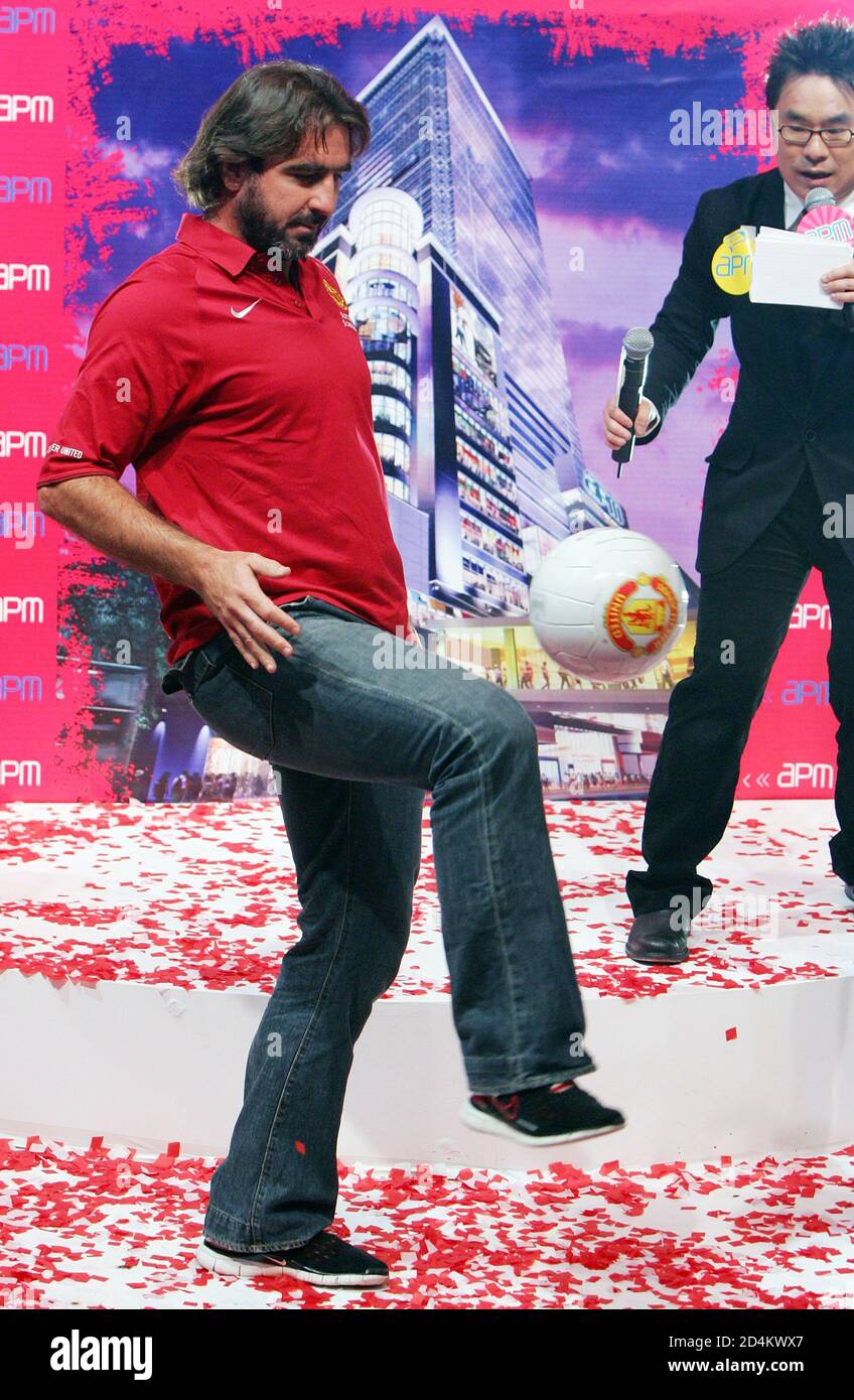 Former Manchester United player Eric Cantona controls a ball during a promotional tour at a shopping mall in Hong Kong.  Former Manchester United player Eric Cantona controls a ball during a promotional tour at a shopping mall in Hong Kong July 17, 2005. English team Manchester United will play against the Hong Kong National team on July 23, 2005. REUTERS/Paul Yeung Stock Photo