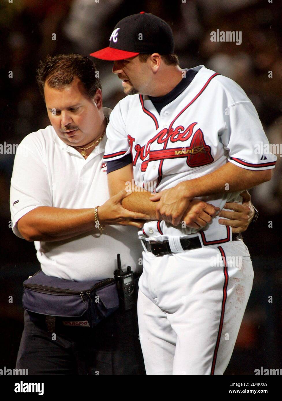Atlanta Braves relief pitcher Jay Powell (R) is led off the field by a  Braves trainer after injuring his arm while throwing in the ninth inning in  Atlanta, Georgia July 29, 2005.