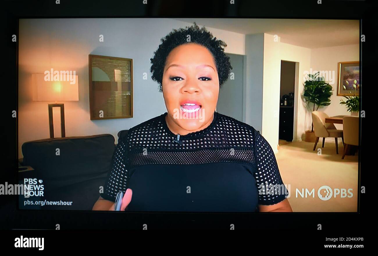 Television screen shot of PBS News Hour White House correspondent Yamiche Alcindor reporting remotely from her home because of the Covid-19 pandemic. Stock Photo