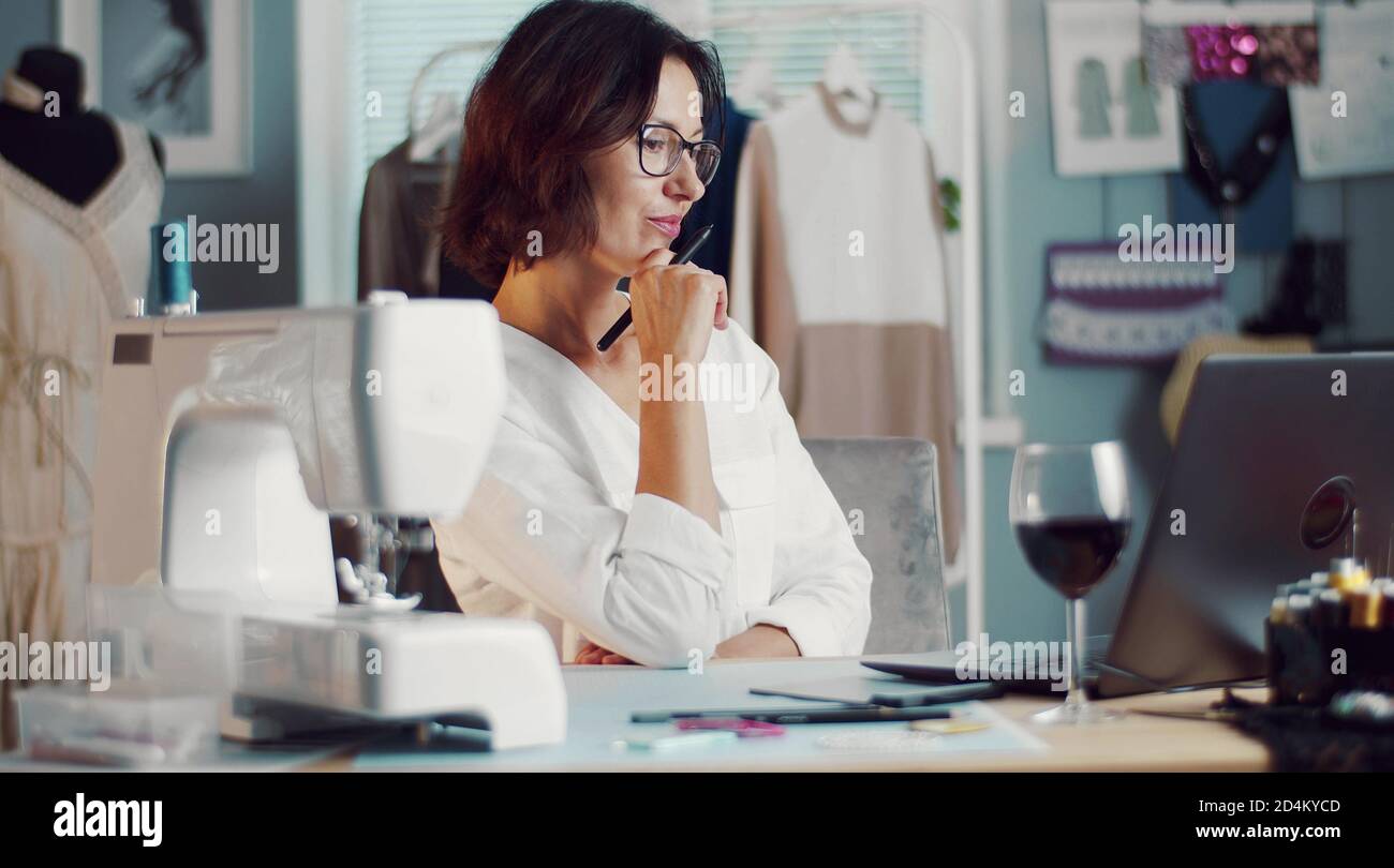 Seamstress working laptop in workshop Stock Photo
