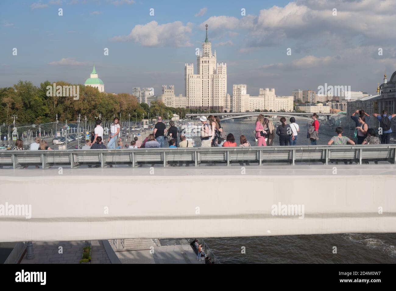 Tourists on the River Overlook, 70-metres long concrete console in Zaryadye park in central Moscow, Russia, against one of Seven Sisters skyscrapers Stock Photo