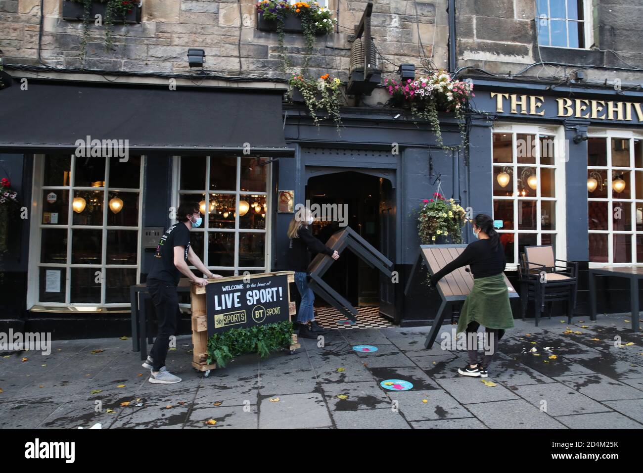 People clear away outside The Beehive Inn in The Grassmarket, Edinburgh, as temporary restrictions announced by First Minister Nicola Sturgeon to help curb the spread of coronavirus have come into effect from 6pm on Friday. Stock Photo