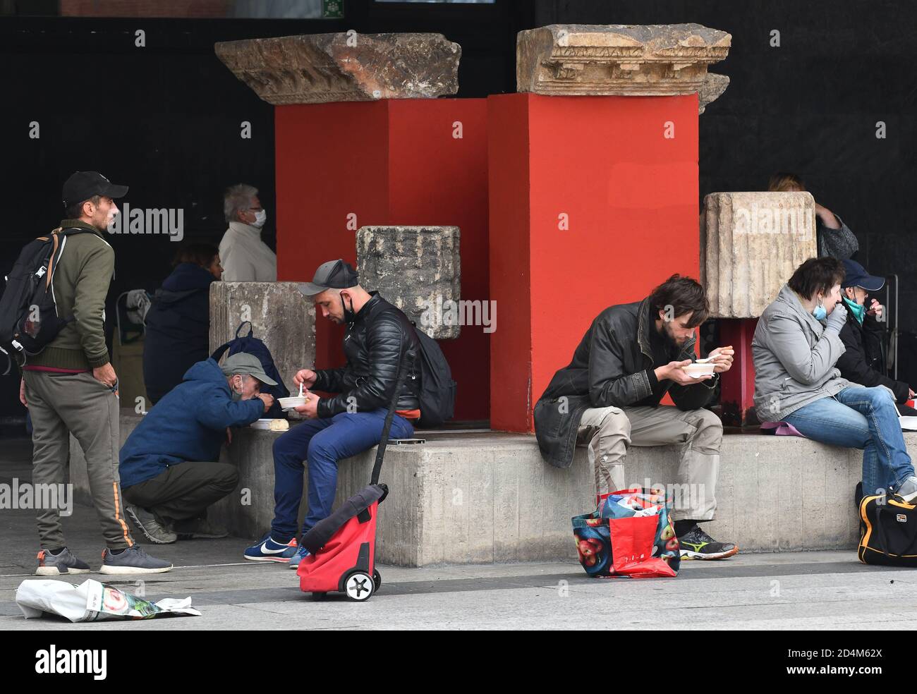 Cologne, Germany.2020. Homeless and poor people eating food provided by  Jutta's soup kitchen outside the Roman-Germanic Museum in Koln.  Verteilung v Stock Photo