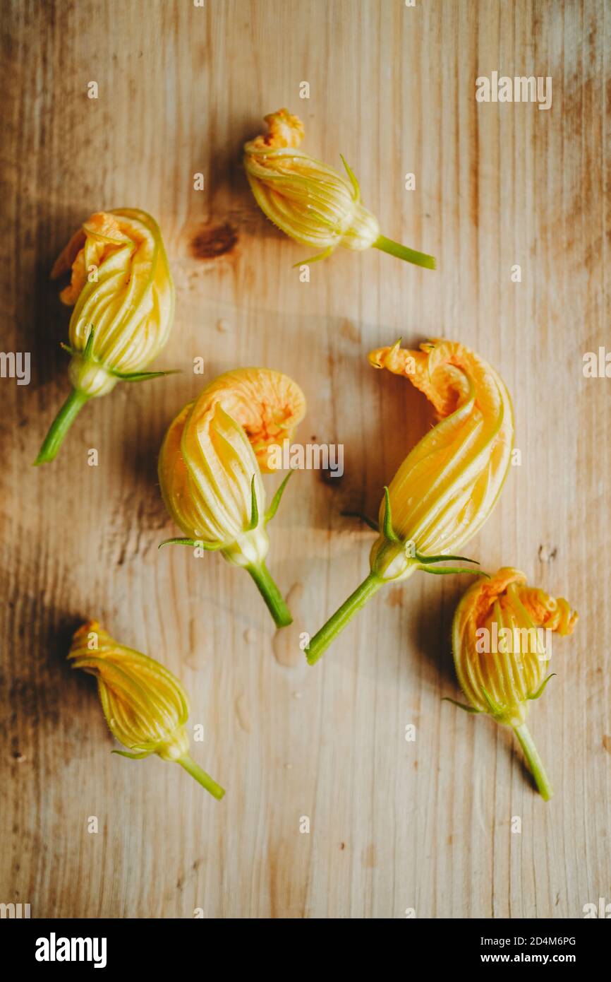 High angle view of courgette flowers on a wooden table Stock Photo
