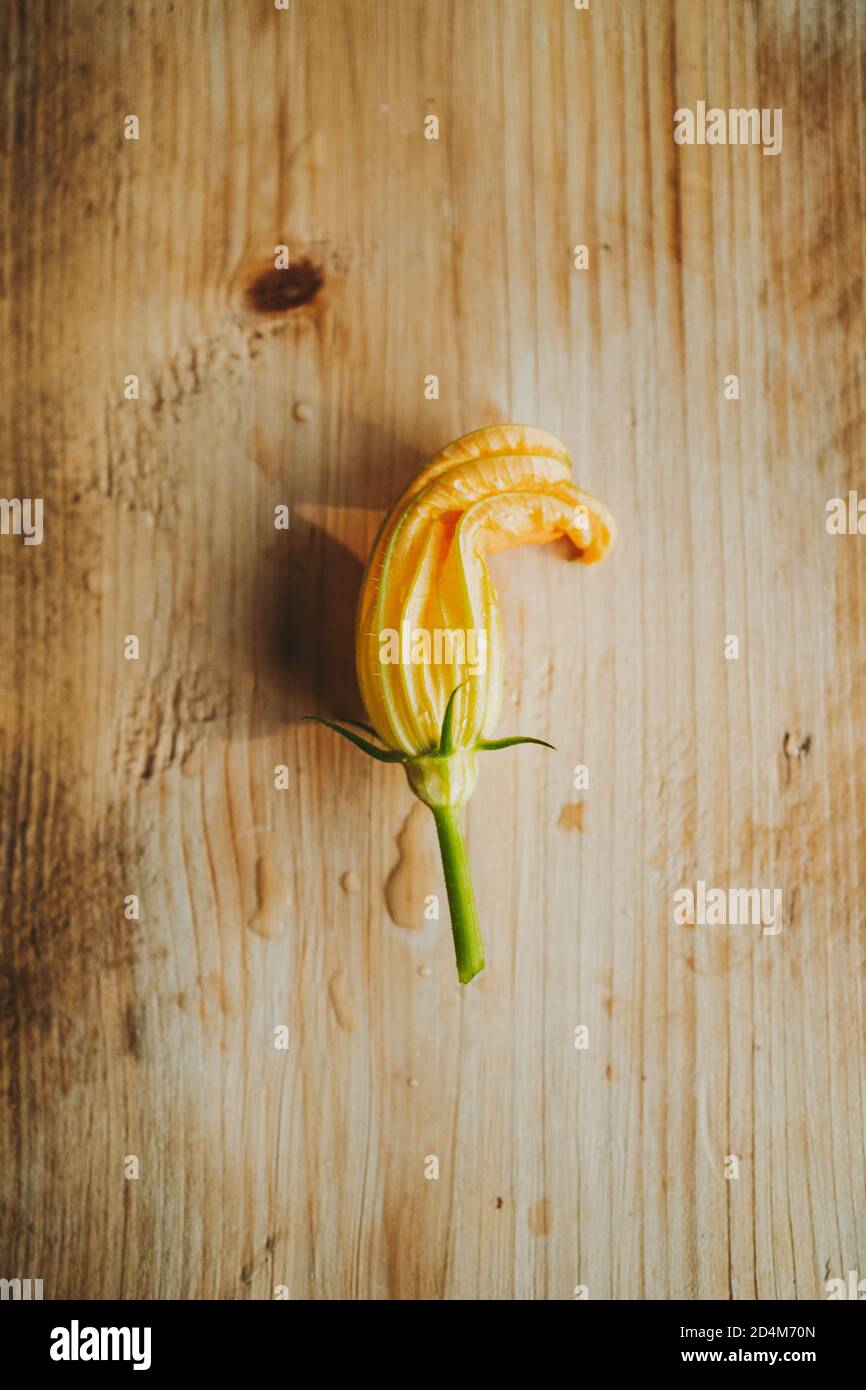 High angle view of courgette flowers on a wooden table Stock Photo