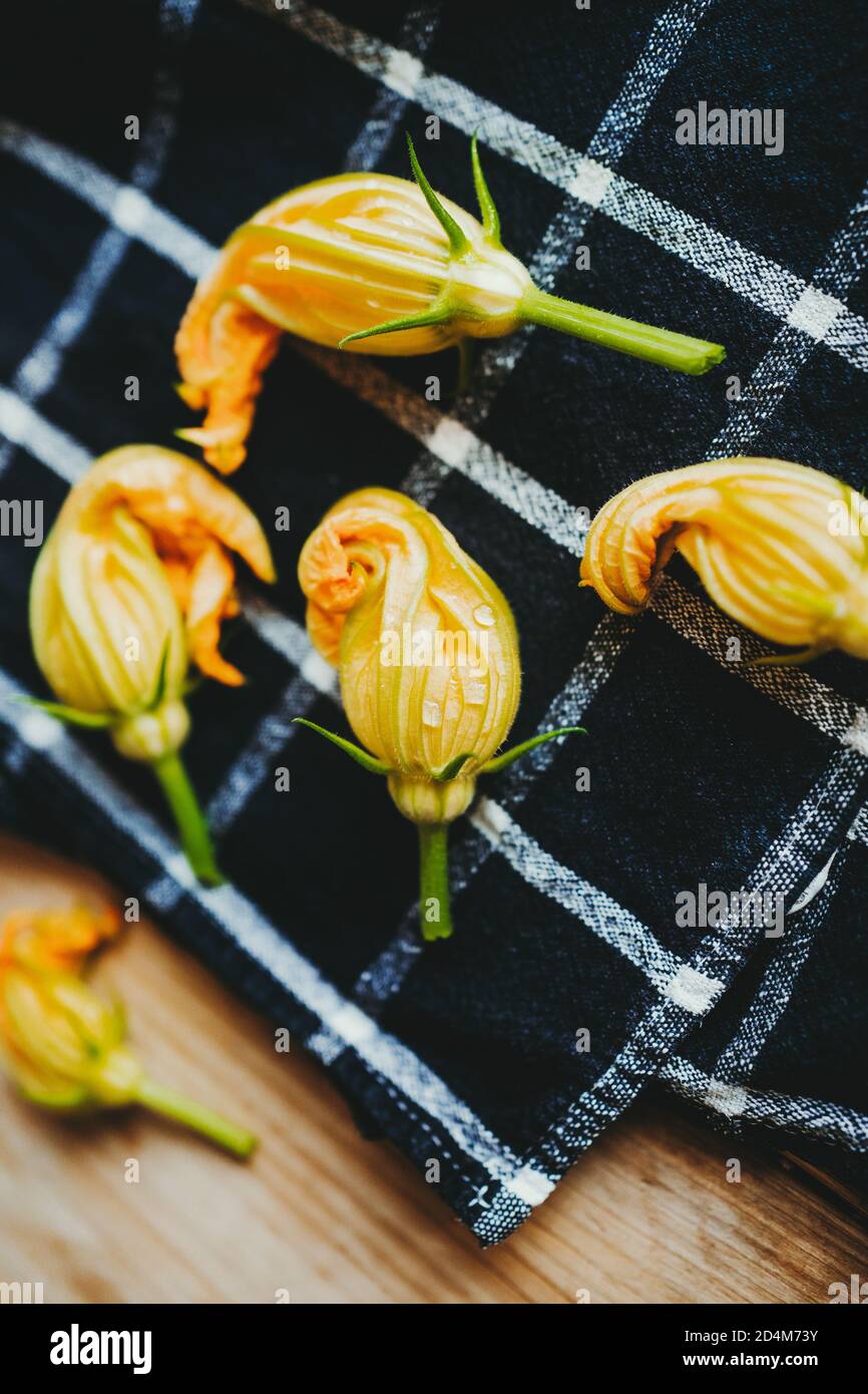 Yellow courgette flowers on a black towel Stock Photo