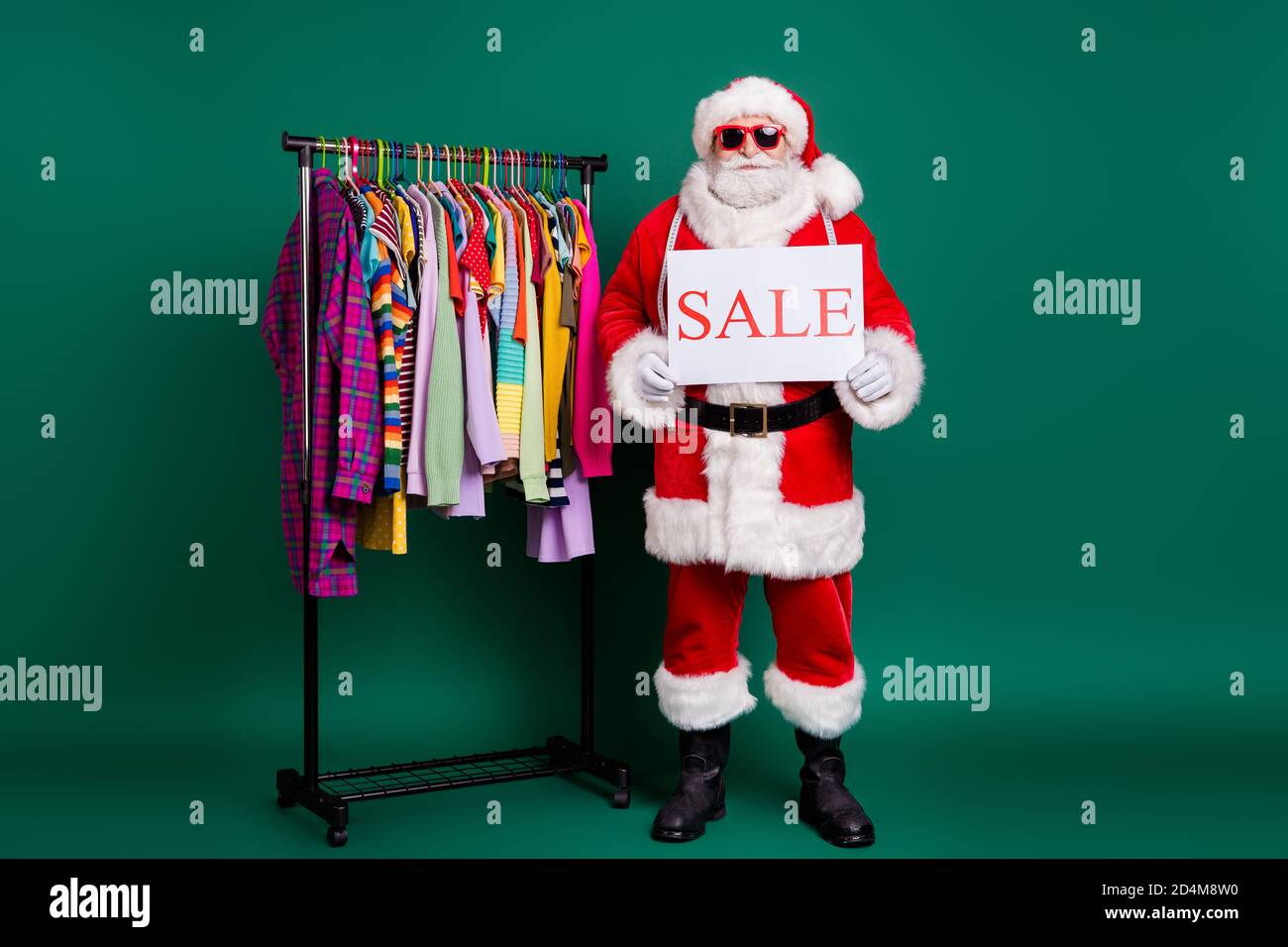 Full length body size view of his he nice fat funny Santa St Nicholas selling outlet season clothes holding in hands poster sale bargain aassortment Stock Photo