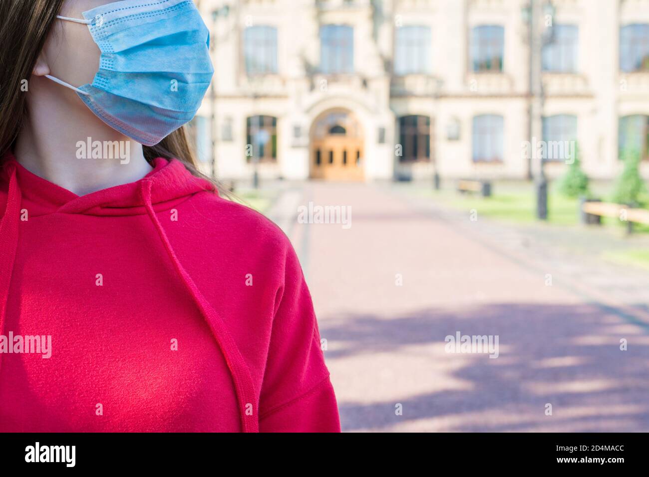Cropped close up photo portrait of young girl in casual red jumper wearing surgical medicine mask going to hospital Stock Photo