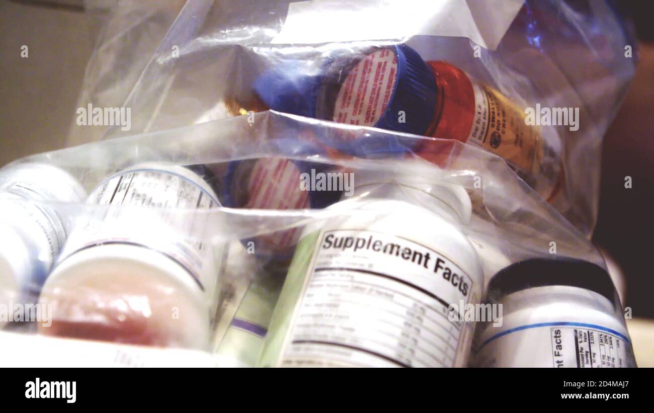 medicine pills bottles, vitamins and supplements in plastic bag close