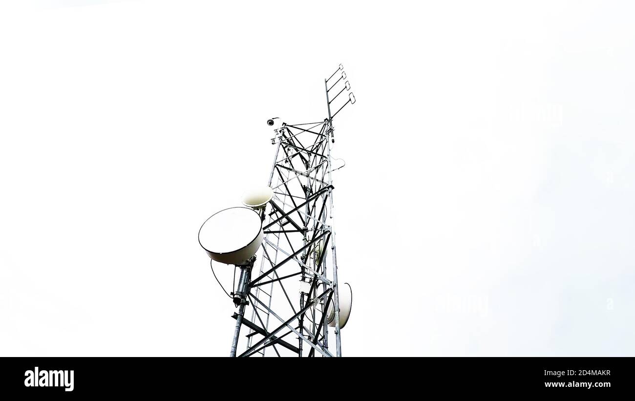 Radio antenna tower telecommunication against cloudy sky in low angle view. Isolated on white background. Stock Photo