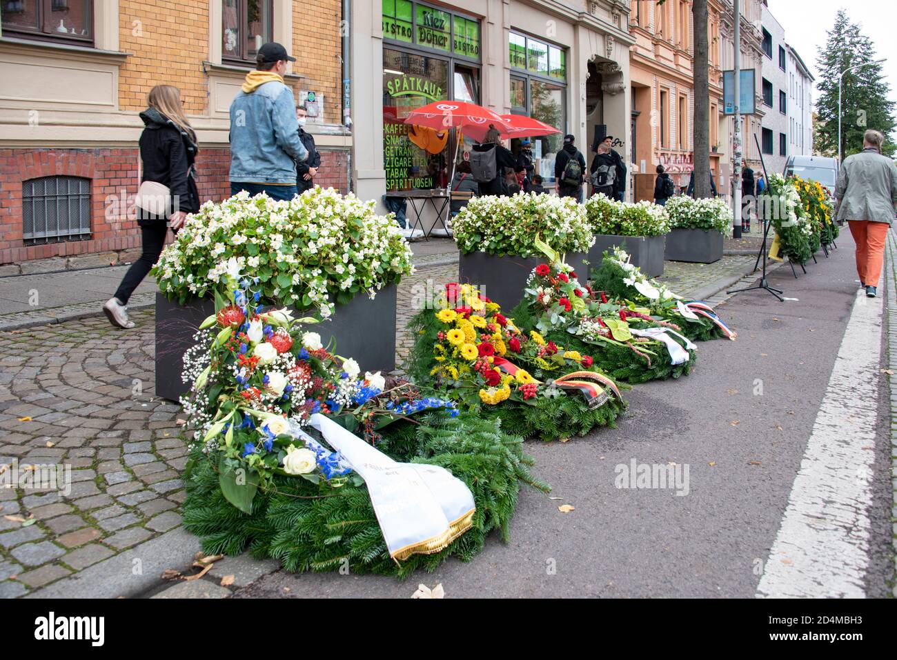 Halle, Germany. 9th Oct 2020. Wreaths stand in front of a kebab snack in Halle. They commemorate a 20-year-old painter's apprentice who was shot here a year ago by a right-wing extremist. The terrorist had previously attempted to cause a massacre in a synagogue. When he failed to do so because he could not open the entrance door to the synagogue, he shot two people while fleeing and seriously injured others. The city of Halle in Germany commemorated all day today the victims who died one year ago on October 9, 2019. Credit: Mattis Kaminer/Alamy Live News Stock Photo