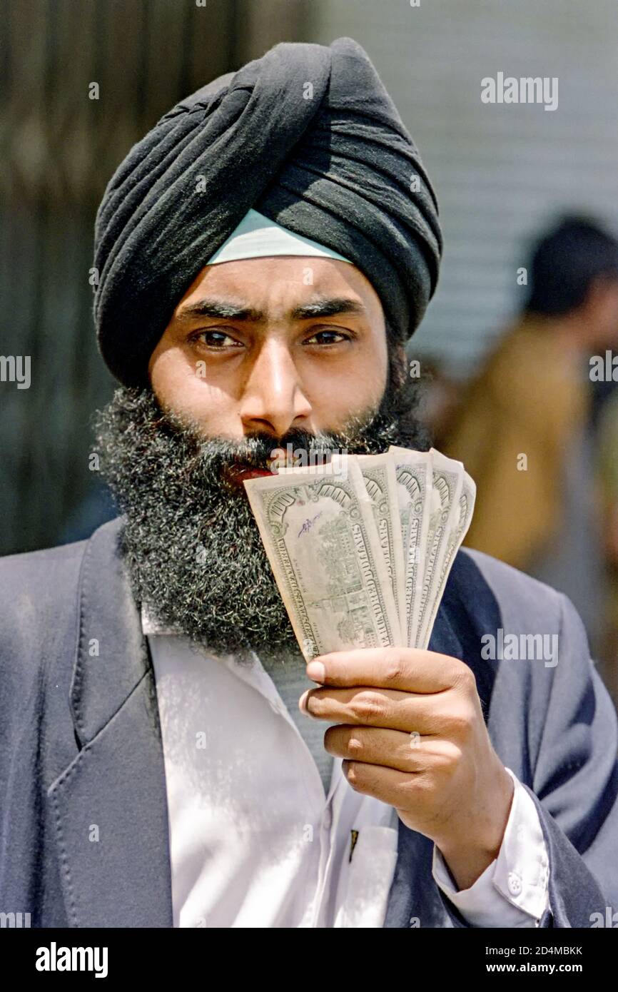 A Sikh money trader holds a stack of U.S. Dollars at the blackmarket