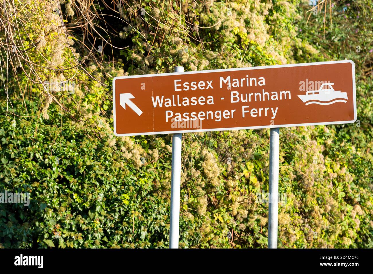 Brown sign for Essex Marina, Wallasea to Burnham passenger ferry, in Rochford, Essex, UK. Direction arrow with boat graphic. Rural area Stock Photo