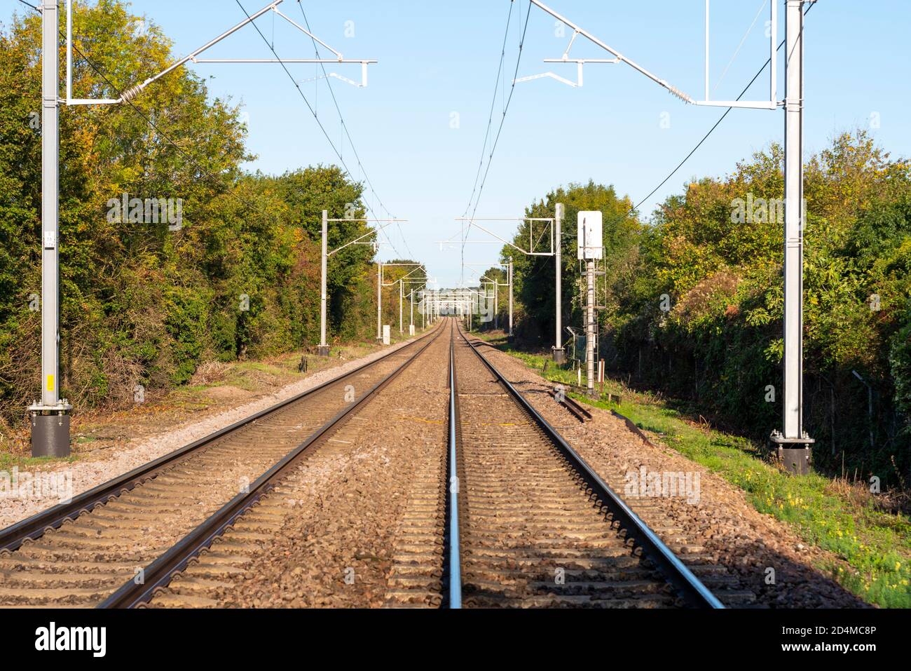Straight railway. Section of long, straight railway line at Hawkwell, Rochford, Essex, UK. Greater Anglia. Crossed by public footpath on fast stretch Stock Photo