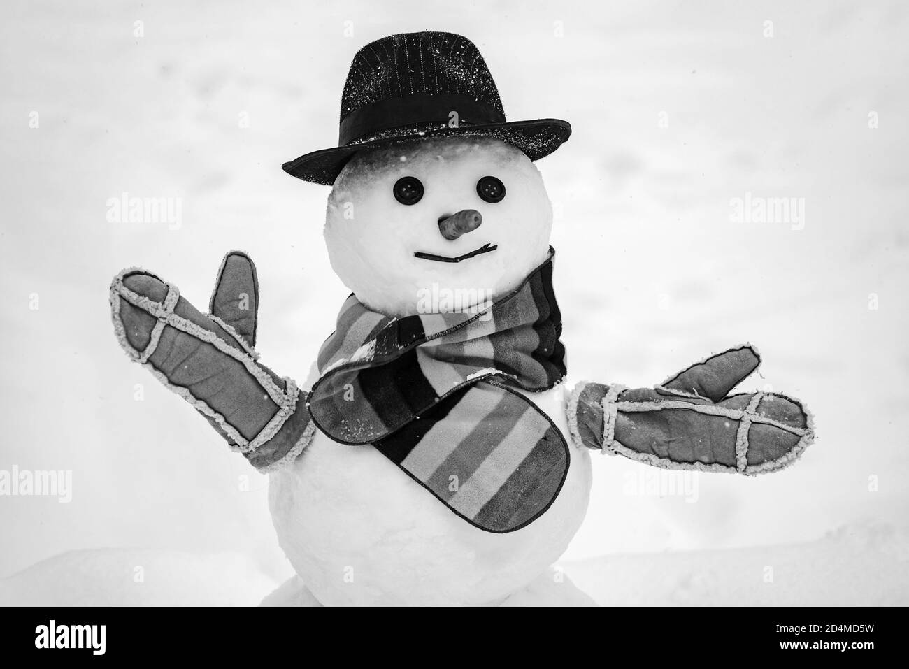 Cute snowman at a snowy village. Snowman. Snowmen. Making snowman and winter fun. Cute little snowman outdoor. Stock Photo