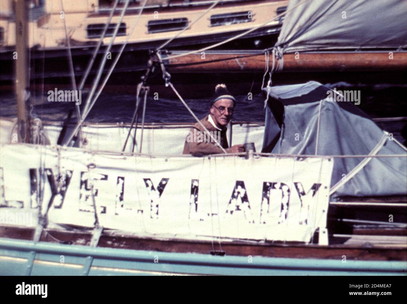 AJAXNETPHOTO. 4 JULY, 1968. SOUTHSEA, ENGLAND. - SAILING GROCER RETURNS - ALEC ROSE AT THE HELM OF HIS 36FT KETCH LIVELY LADY AS SHE RETURNED TO PORTSMOUTH AT THE END OF HIS SOLO ROUND THE WORLD VOYAGE. THE GREENGROCER FROM SOUTHSEA SAILED FROM THE CITY ON JULY 16TH, 1967. HIS WAS THE ONLY YACHT UNDER 40FT TO HAVE SAILED AROUND THE WORLD WITH TWO STOPS OR LESS AND THE SECOND YACHT OF ANY SIZE TO HAVE COMPLETED THE 28,000 MILE VOYAGE. ROSE WAS ALSO THE SECOND GROCER IN HISTORY TO BE ELECTED A MEMBER OF THE ROYAL YACHT SQUADRON.(FIRST WAS SIR THOMAS LIPTON). PHOTO:JONATHAN EASTLAND/AJAX REF:2120 Stock Photo