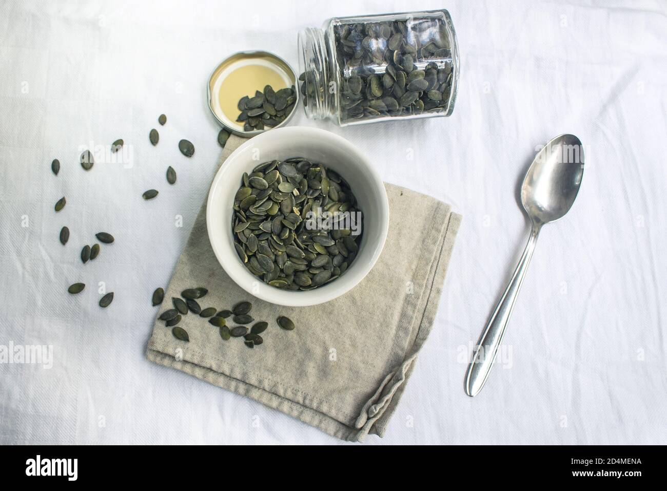 Shot from above onto a bowl and a jar filled with pumpkin seeds Stock Photo