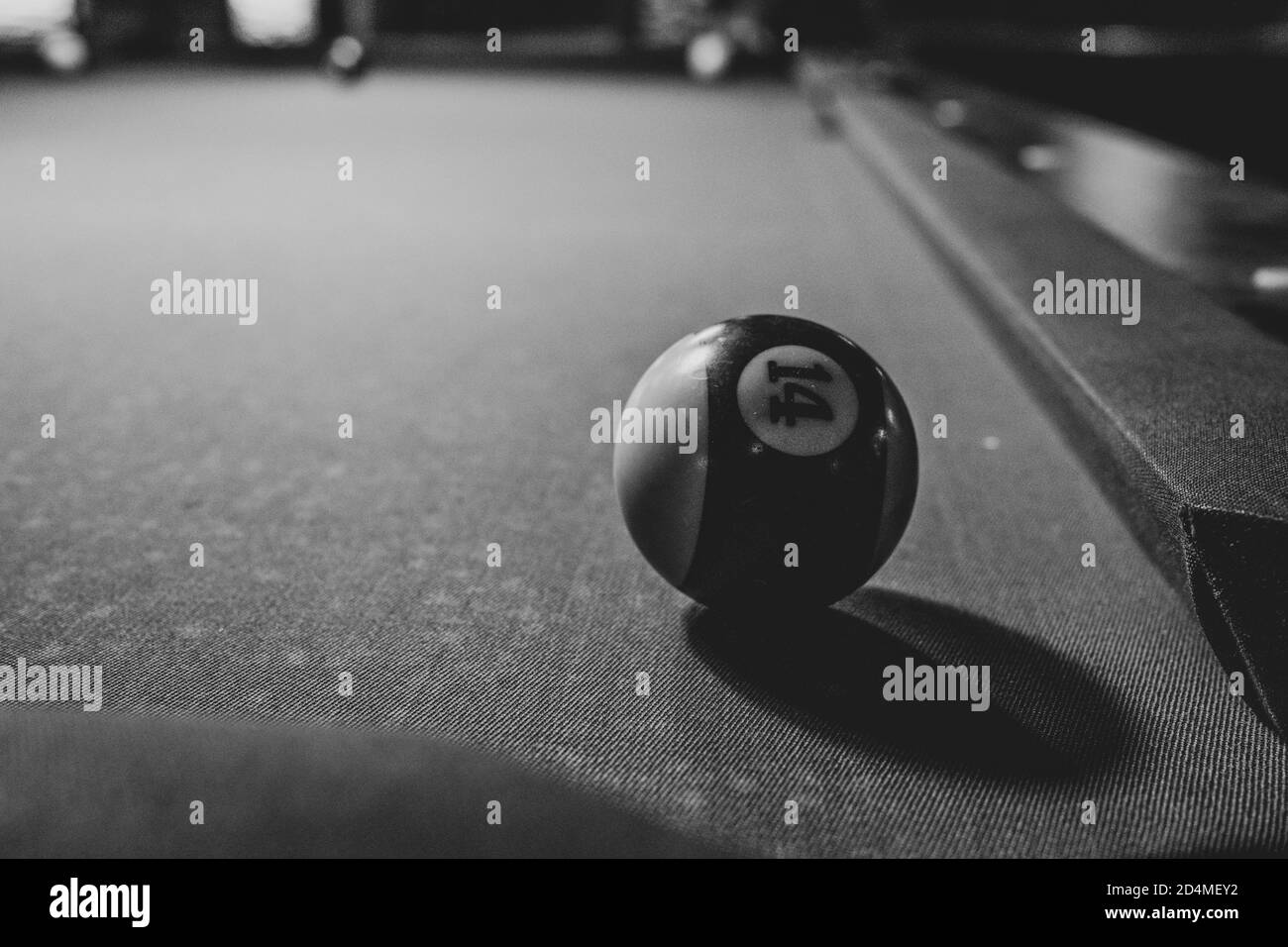 on a billiard table lies a billiard ball in front of a hole Stock Photo