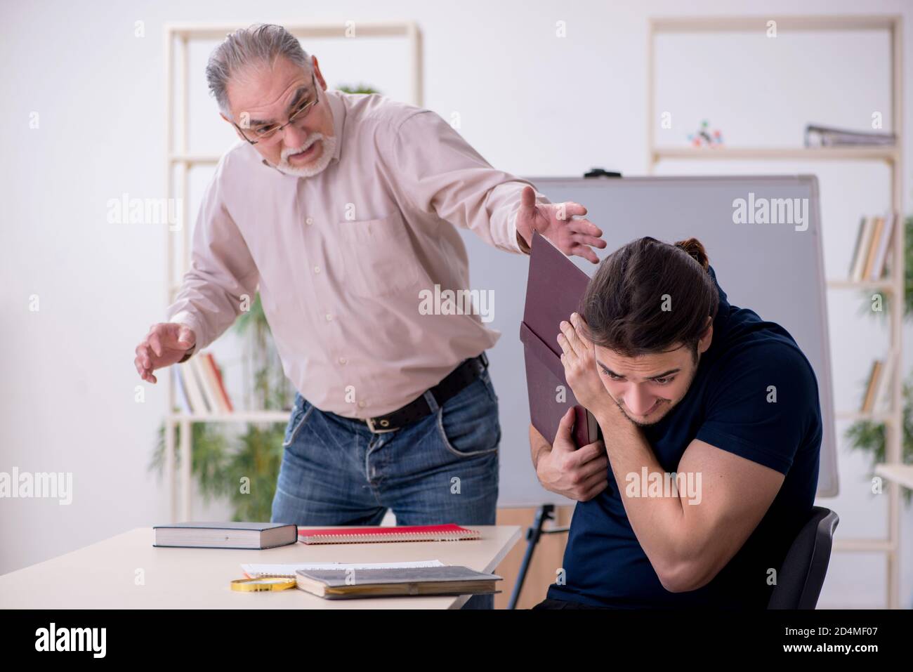 Old teacher and young student in the classroom Stock Photo