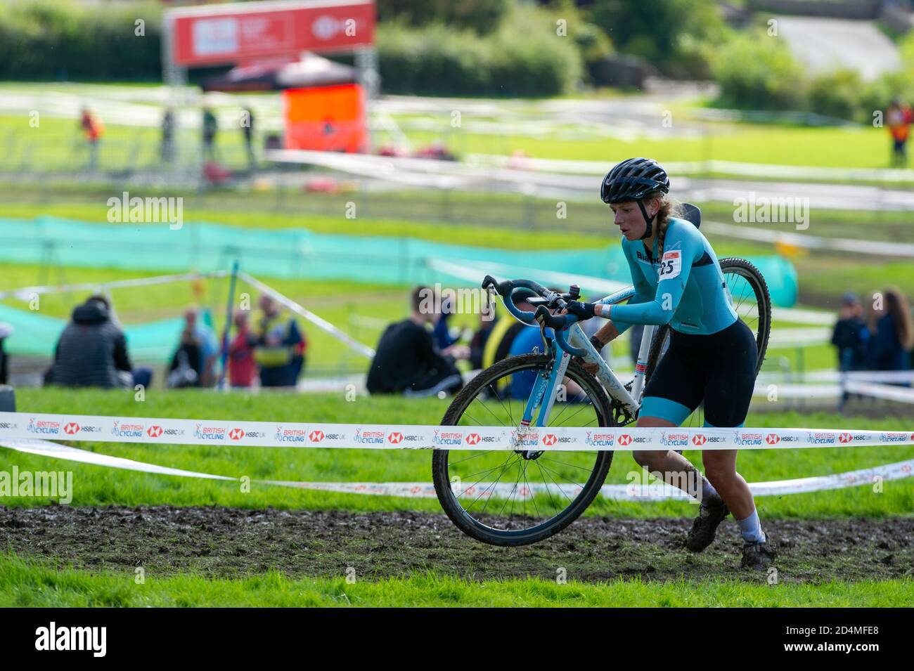 Westmorland County Showground, Cumbria, UK, 4th October 2020. Natasha  Reddy, Bianchi Dama, carries her bike through the mud during the Elite  Womens race at Round 1 of the HSBC British Cycling National