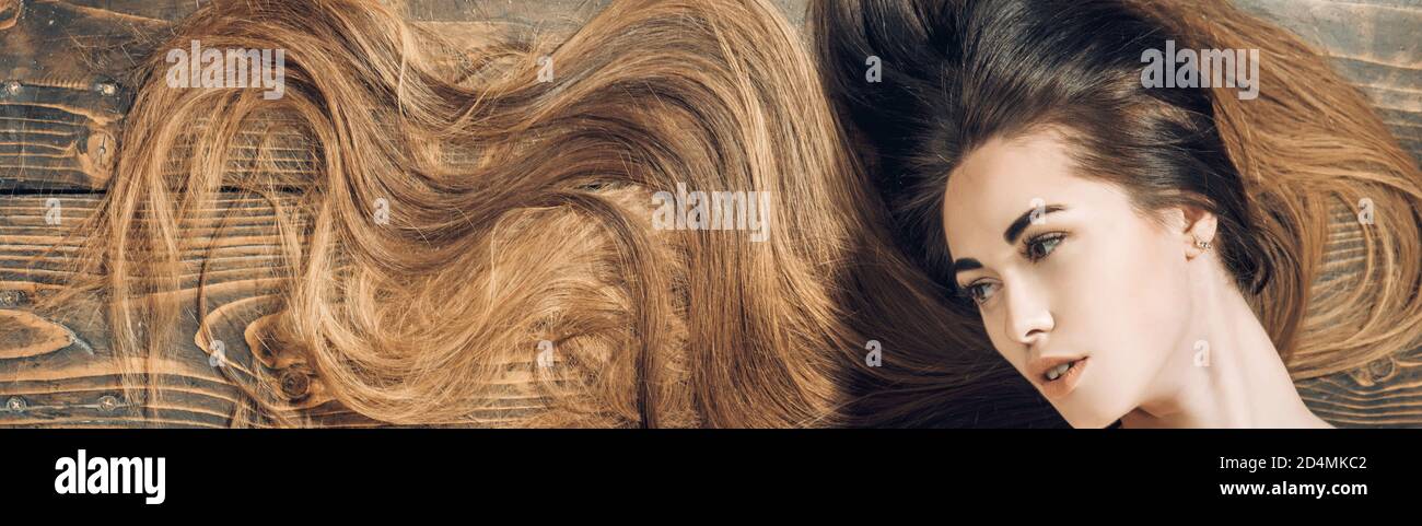 natural girl with long healthy hair. Longhair and hairstyle concept. Hair salon concept. Brunette girl with long and shiny wavy hair. Stock Photo