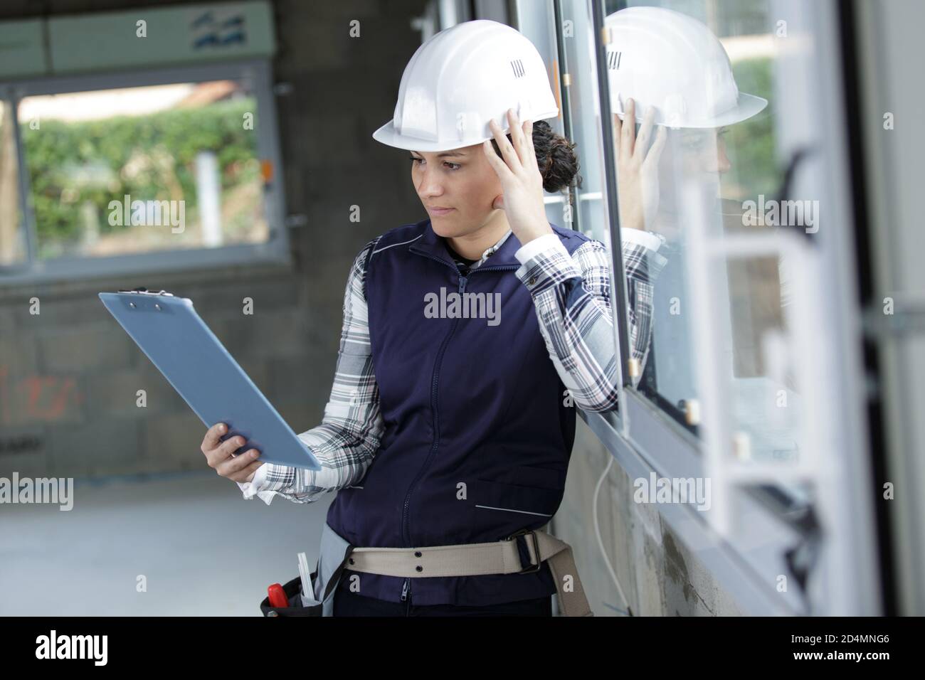 Building With Check Notes woman builder checking her cardboard notes Stock Photo - Alamy