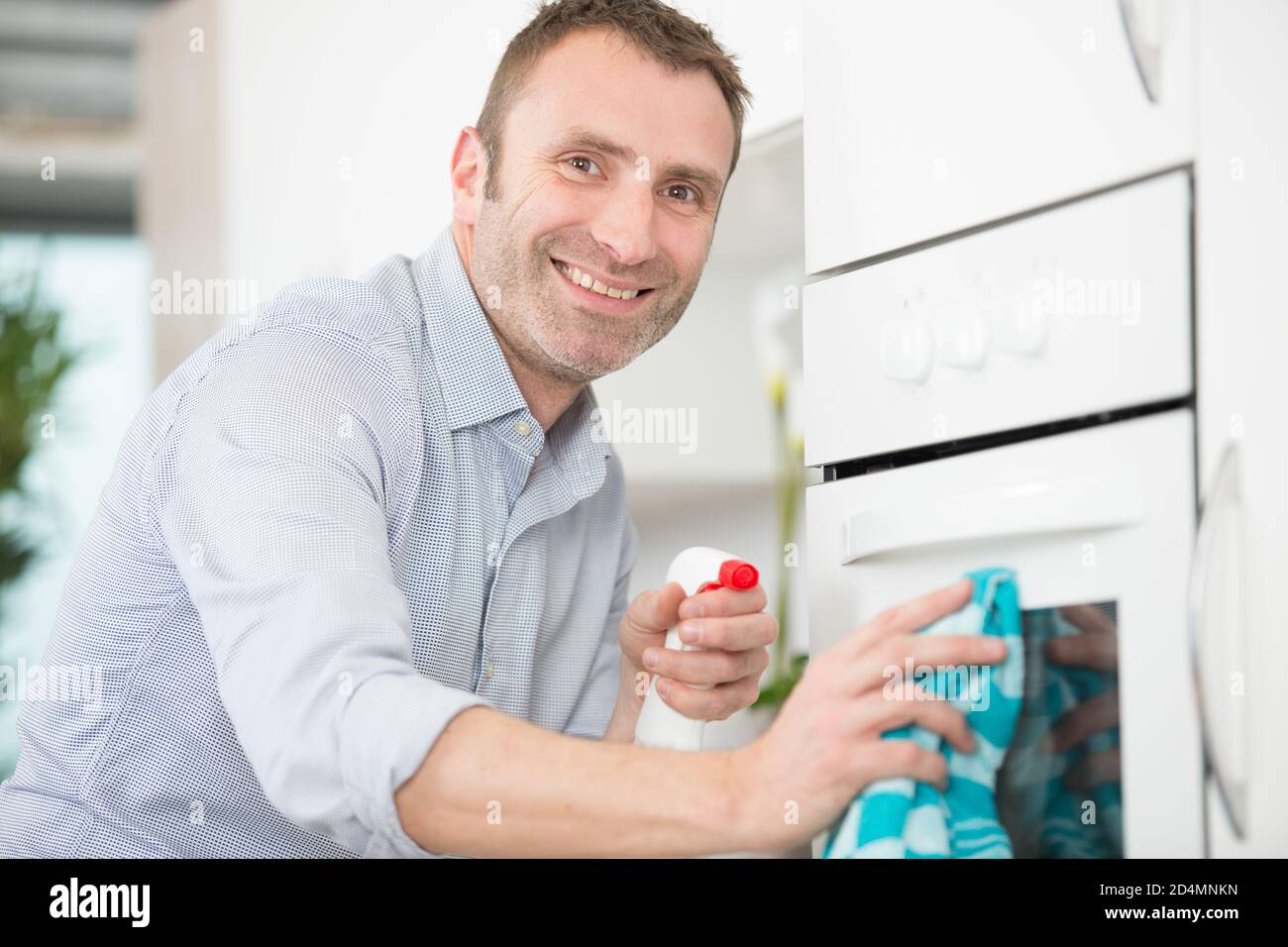 a man is cleaning oven Stock Photo