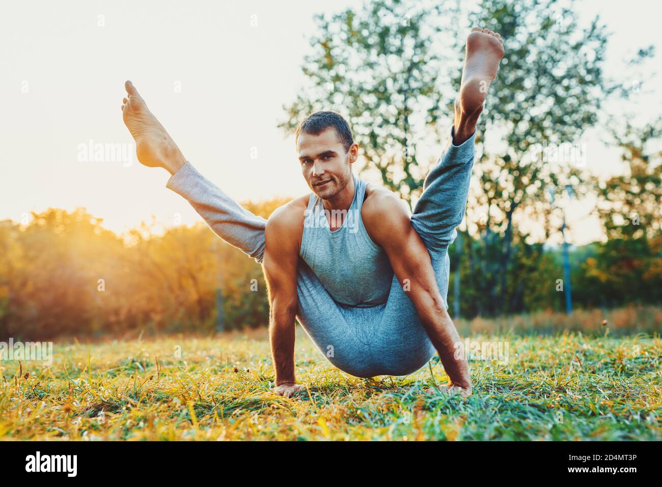 Yogi man training in city park. Warm sunset light. Stock Photo