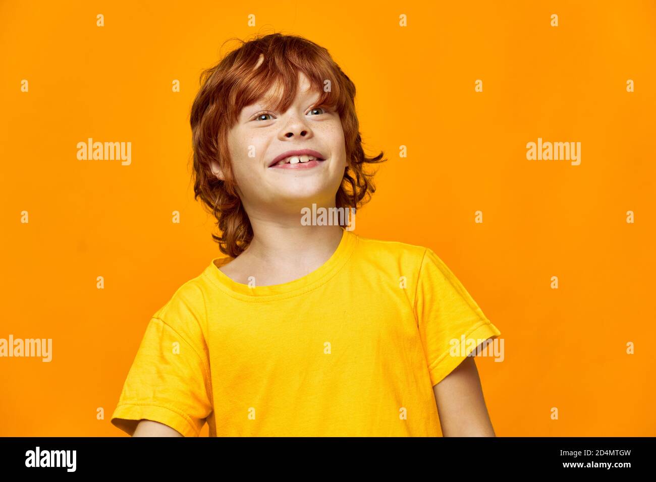 boy in a yellow T-shirt on a yellow background looks to the side Stock ...