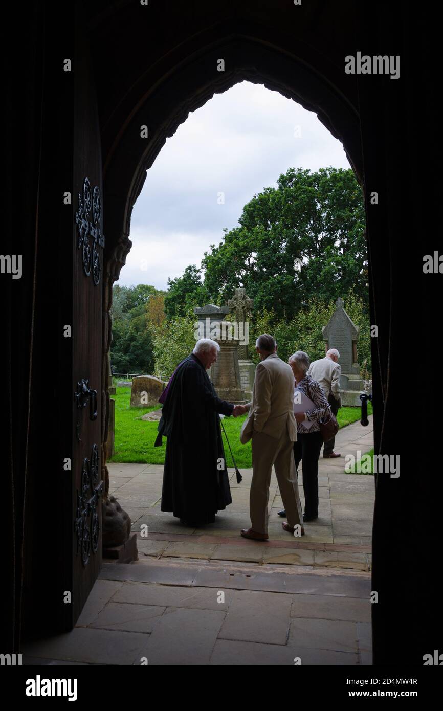The priest greeting the parishioners at the exit of the mass Stock Photo