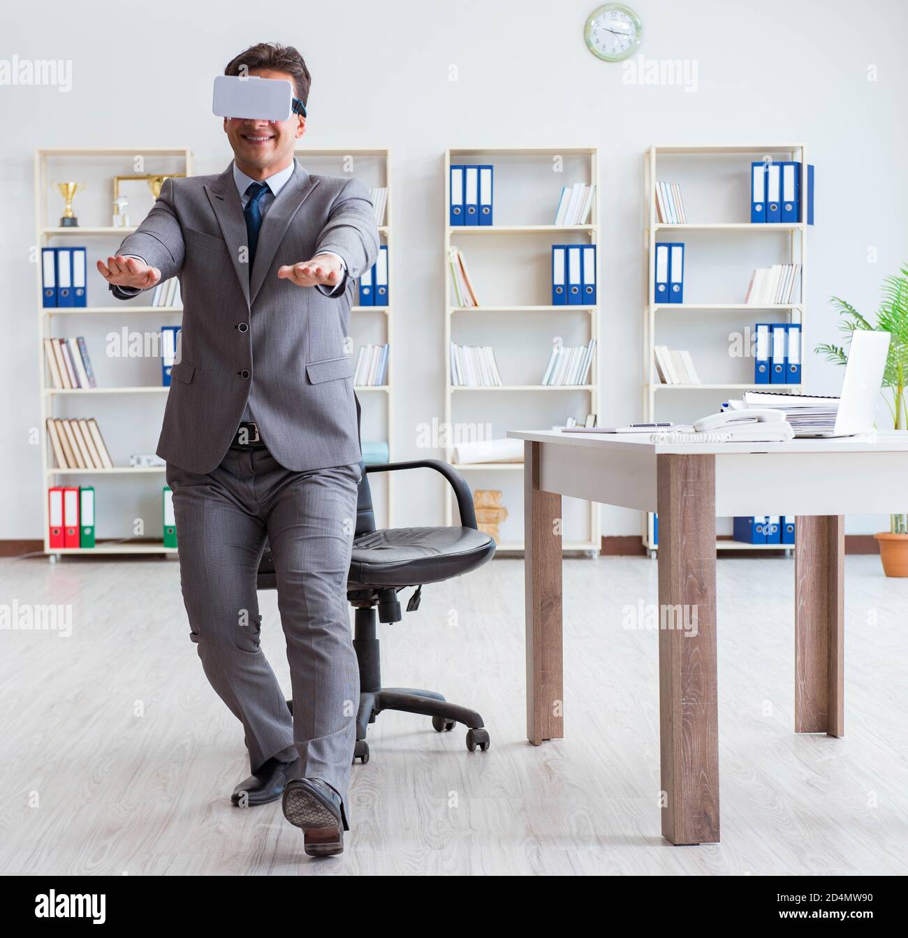The businessman exercising in office wearing vr glasses Stock Photo - Alamy