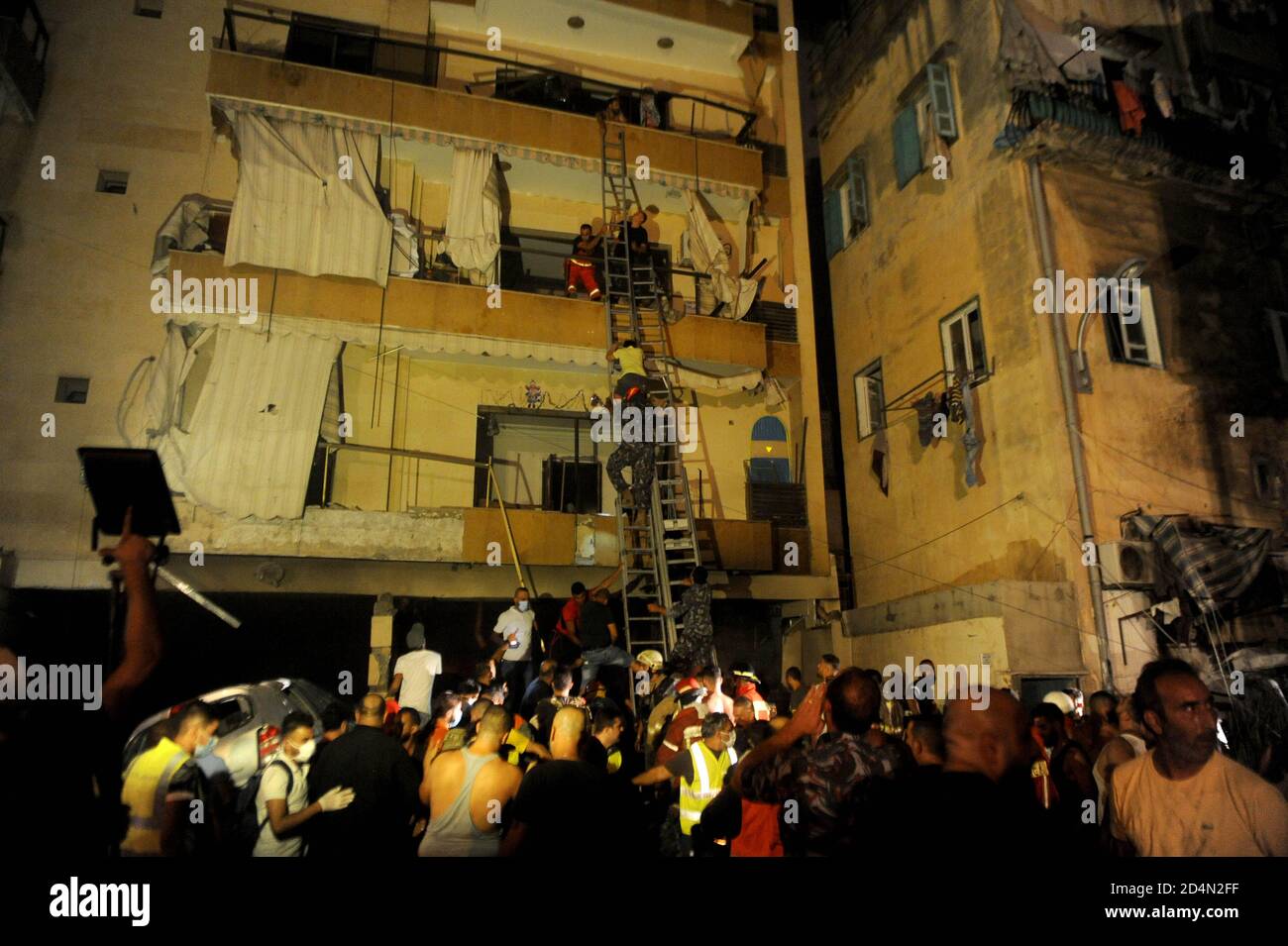 Beijing, Lebanon. 9th Oct, 2020. Civil defense members help people evacuate from a building after a warehouse explosion in Tariq El Jdide neighborhood in Beirut, Lebanon, Oct. 9, 2020. Two people were dead and more than 20 others injured in an explosion at a warehouse in Lebanon's capital Beirut on Friday night, al-Jadeed TV channel reported. Credit: Bilal Jawich/Xinhua/Alamy Live News Stock Photo