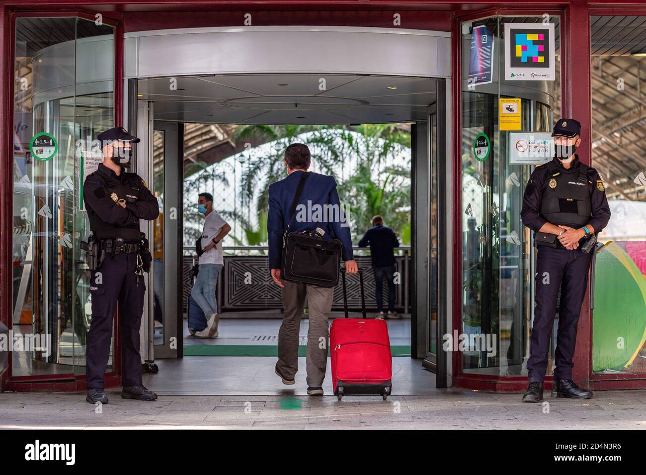 Madrid, Spain. 1st Jan, 2012. The police stands on guard at the door of the Atocha train station during the state of alarm.The Spanish government declared a state of alarm for 15 days in the Community of Madrid due to the high number of Covid 19 infections during the second wave of the pandemic in Spain. Credit: Diego Radames/SOPA Images/ZUMA Wire/Alamy Live News Stock Photo