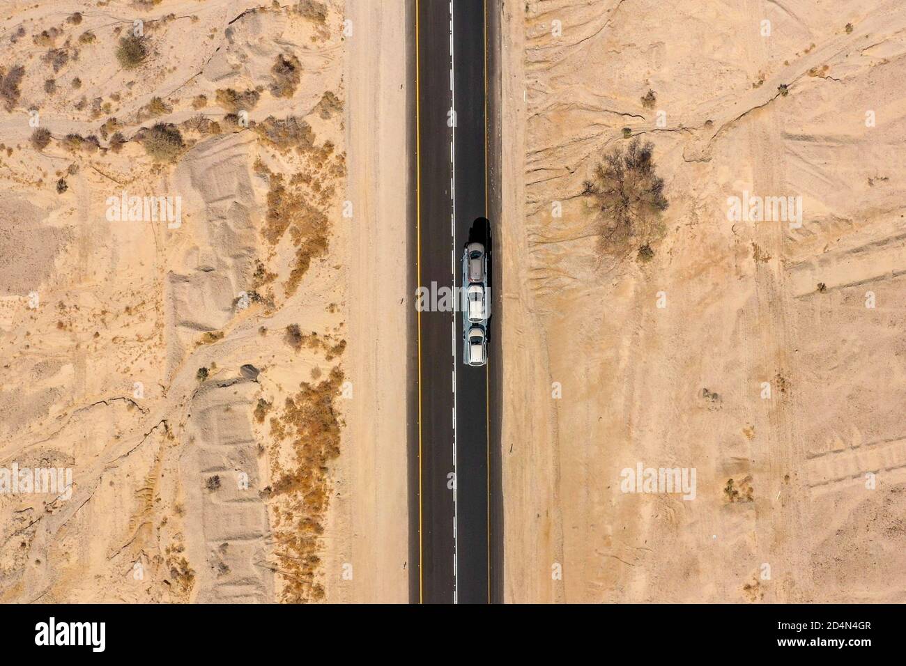 Car Carrier truck heading north on a Desert road, Aerial image. Stock Photo