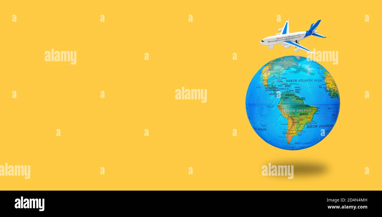Plastic toy plane on the globe. Flight travel concept. Travel by airplane. Takeoff and landing of the aircraft. Return home from flight. Long wide ban Stock Photo