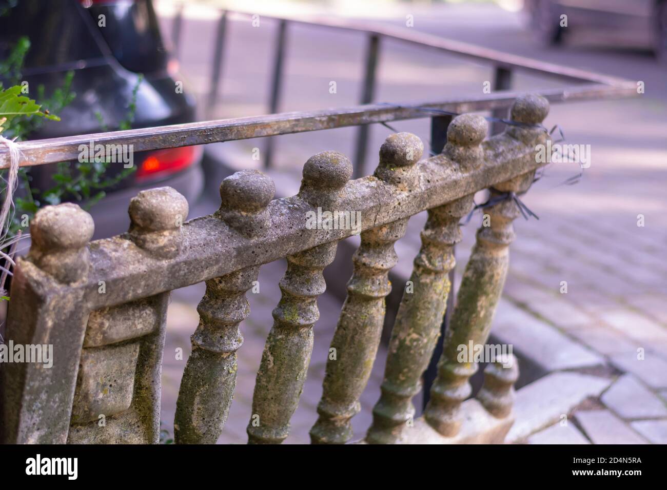 An old stone balustrade in need of repair and restoration. Dilapidated fence. Close-up, selective focus. Stock Photo