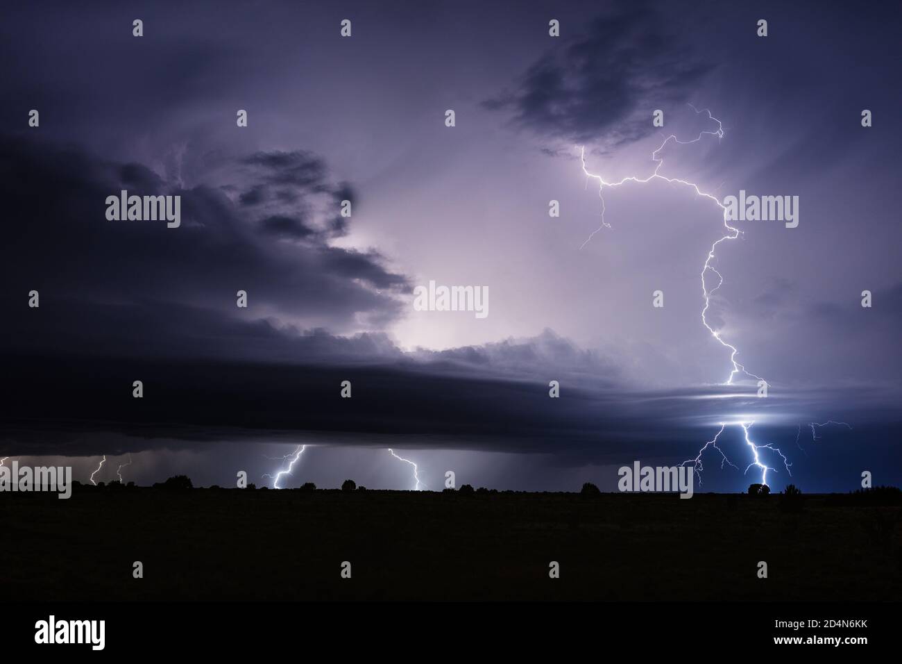 Powerful lightning bolts strike through clouds in a severe thunderstorm ...