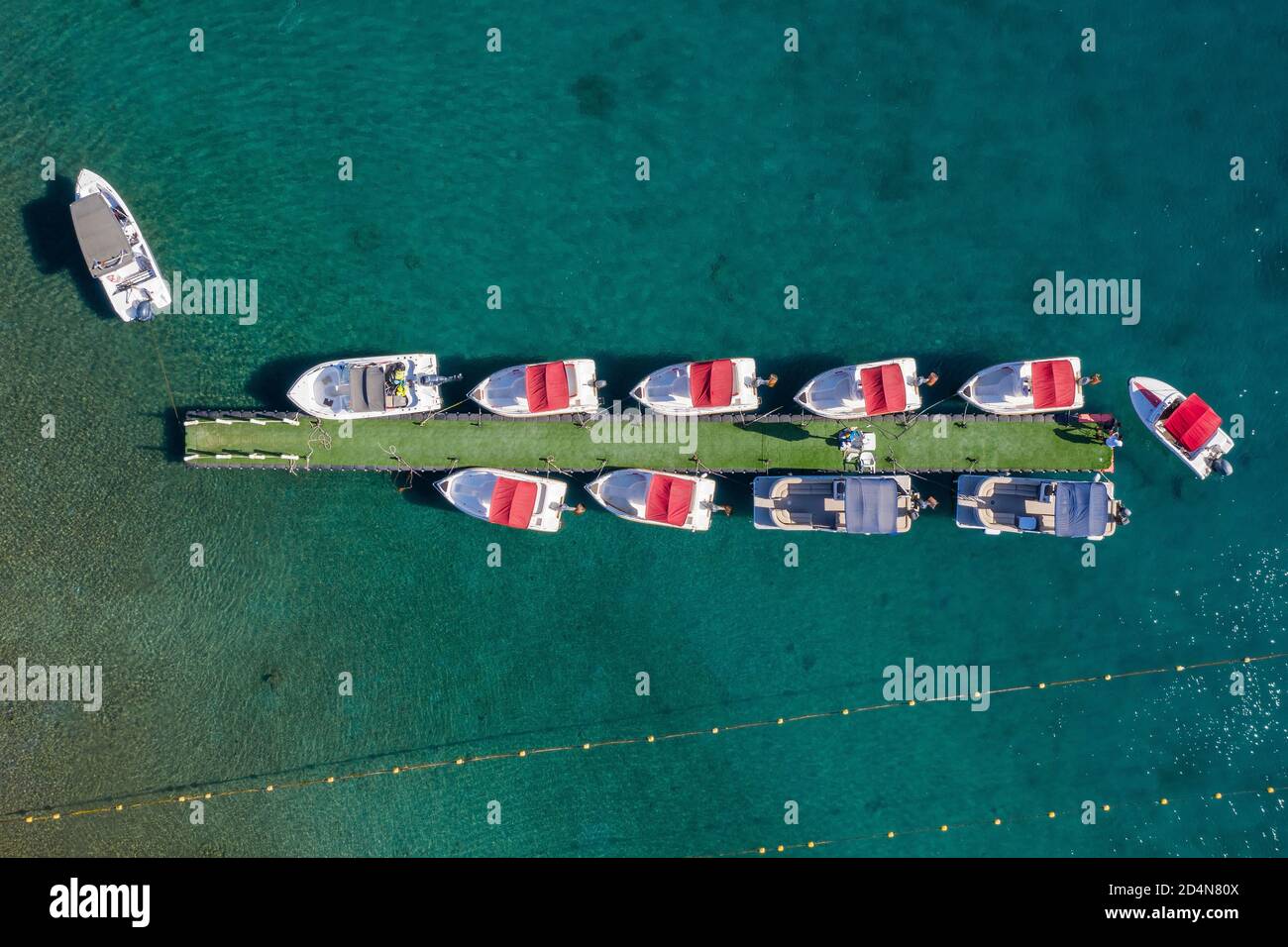 Small boat towing a floating light dock with small boats, Aerial view