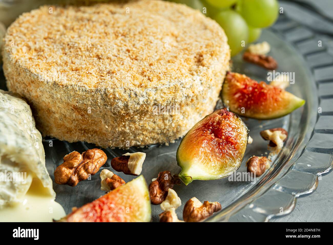 Camembert with grapes, walnuts and figs close-up on the gray background Stock Photo