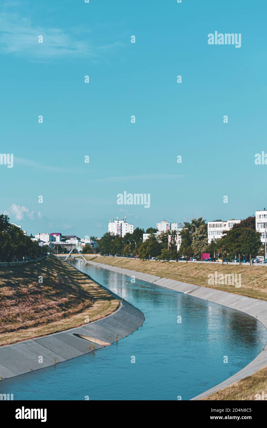 Vertical shot of a narrow river near buildings and trees Stock Photo ...
