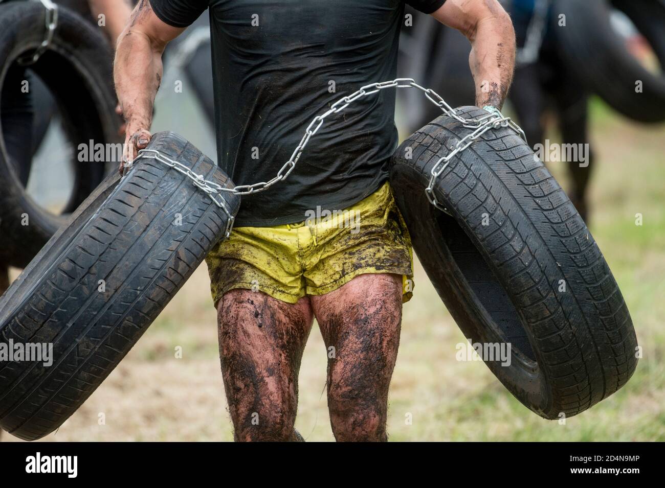 Mud race runner, man running in mud. Runners during extreme obstacle