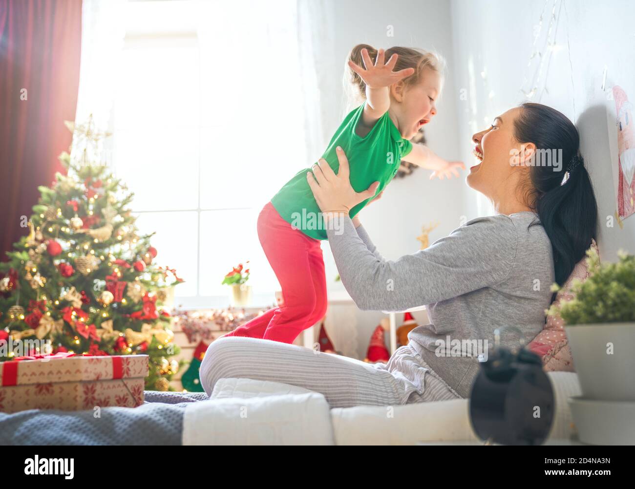 Merry Christmas and Happy Holidays! Cheerful mom giving gift to her